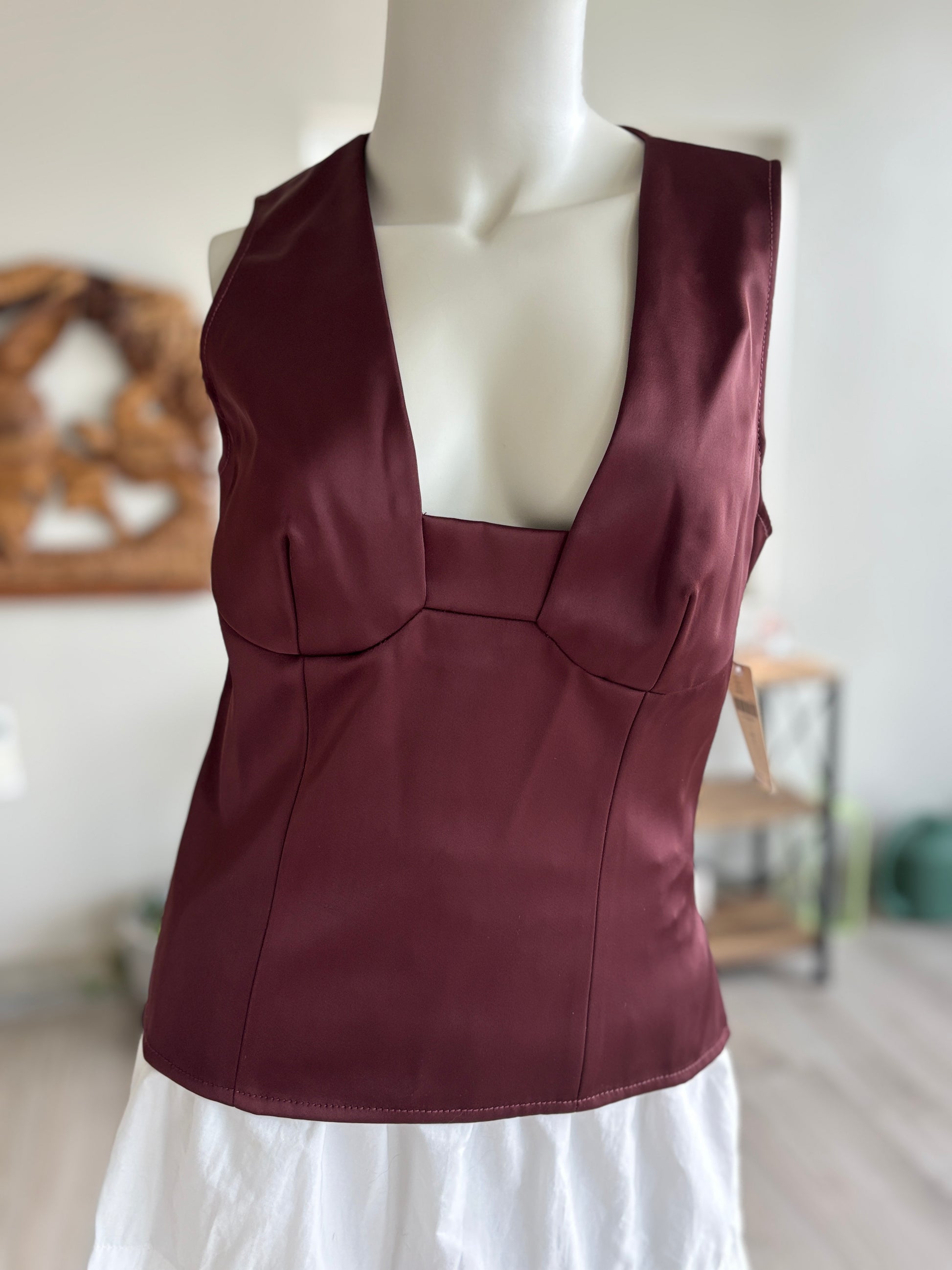 Anthropologie dark merlot satin-effect peplum top with a fitted waist, sleeveless design, and softly flared hem.