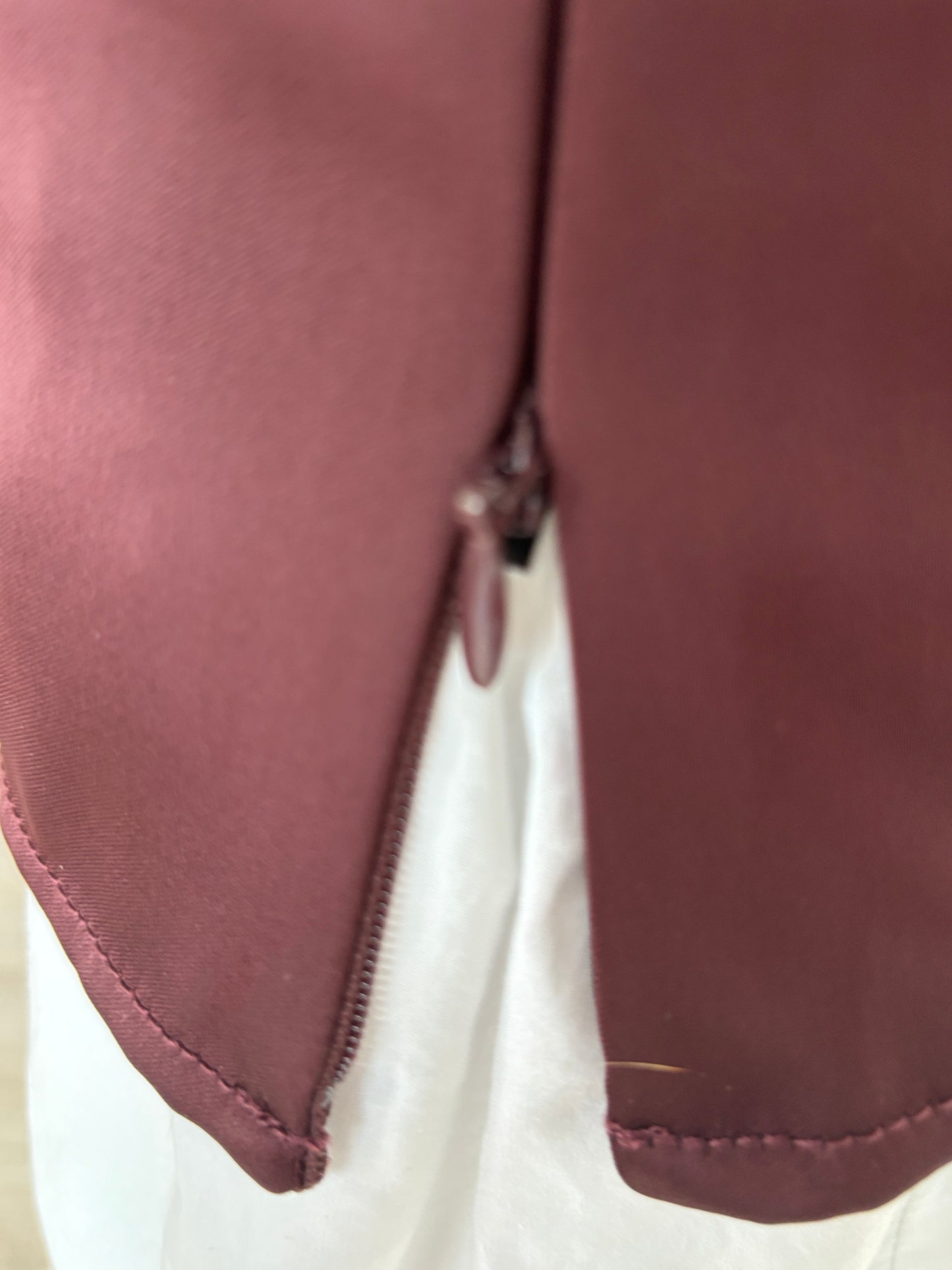 Anthropologie satin-effect deep V-neck top in oxblood burgundy with curved bust seaming and a structured waist.