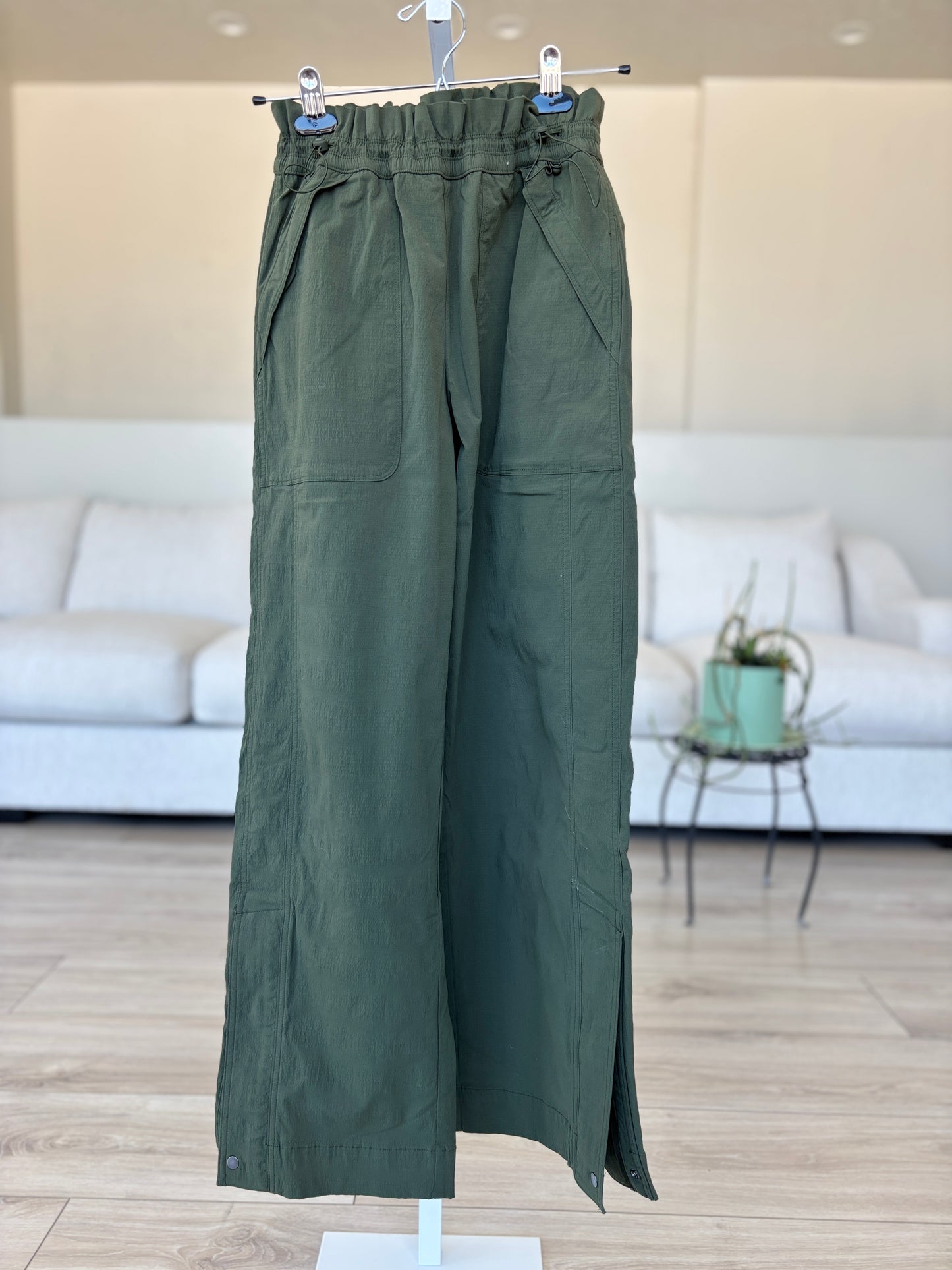 Athleta dark olive travel pants with double cinch waist and 10 inch ankle zip vents from Adored Again boutique