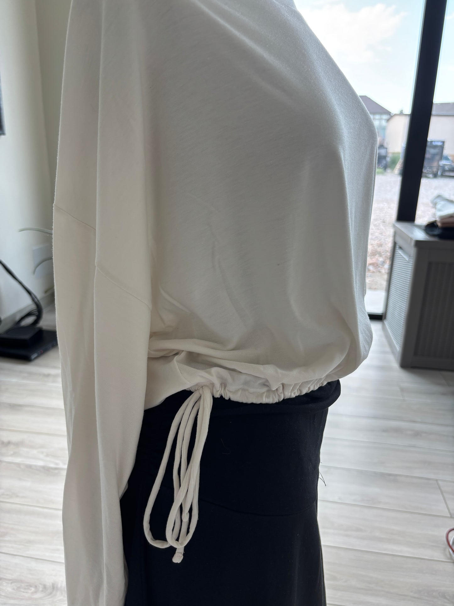 Athleta ivory batwing top featuring a wide neckline, fluid stretch fabric, and decorative tassel-ended hem ties.