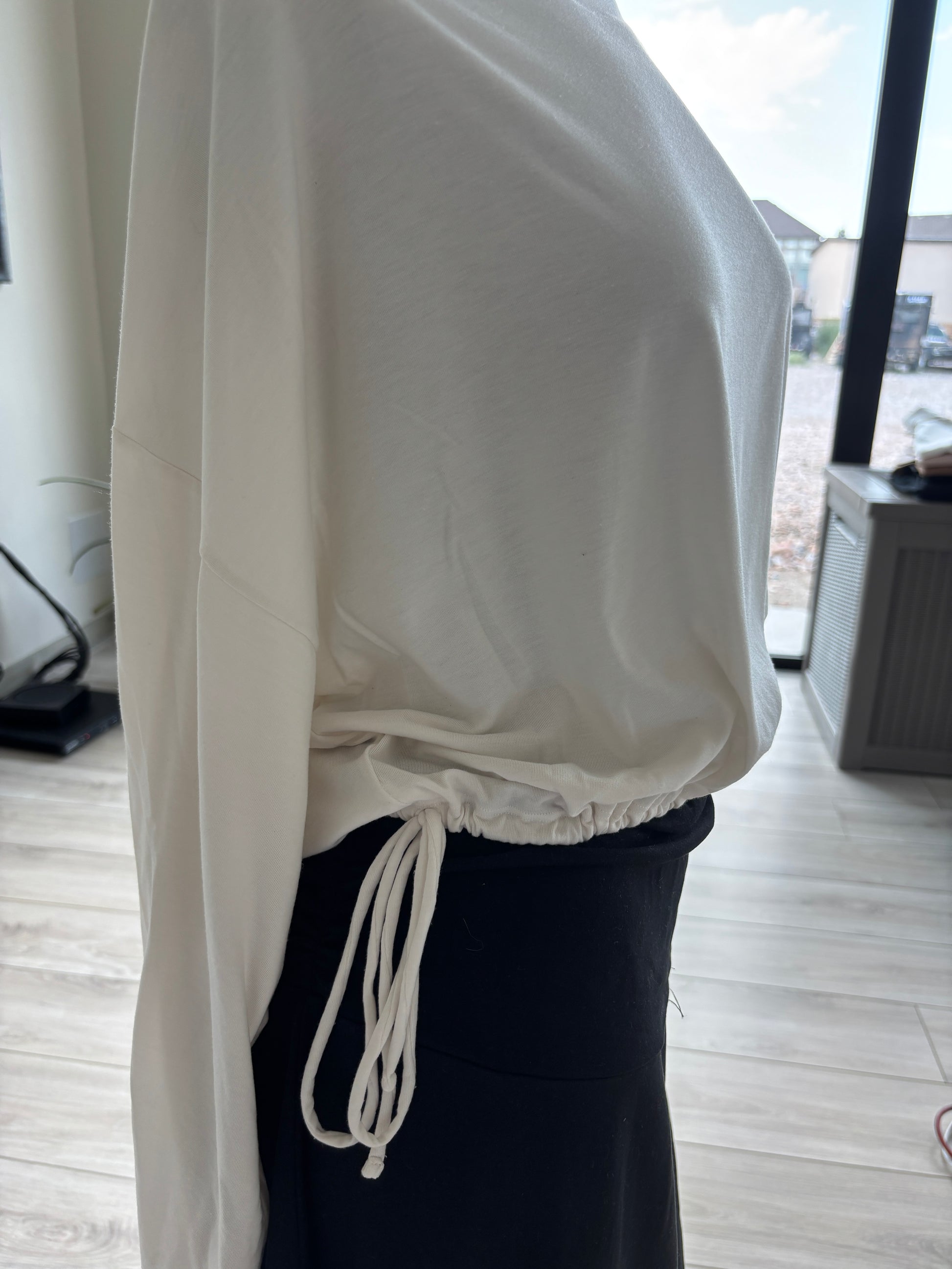Athleta ivory batwing top featuring a wide neckline, fluid stretch fabric, and decorative tassel-ended hem ties.