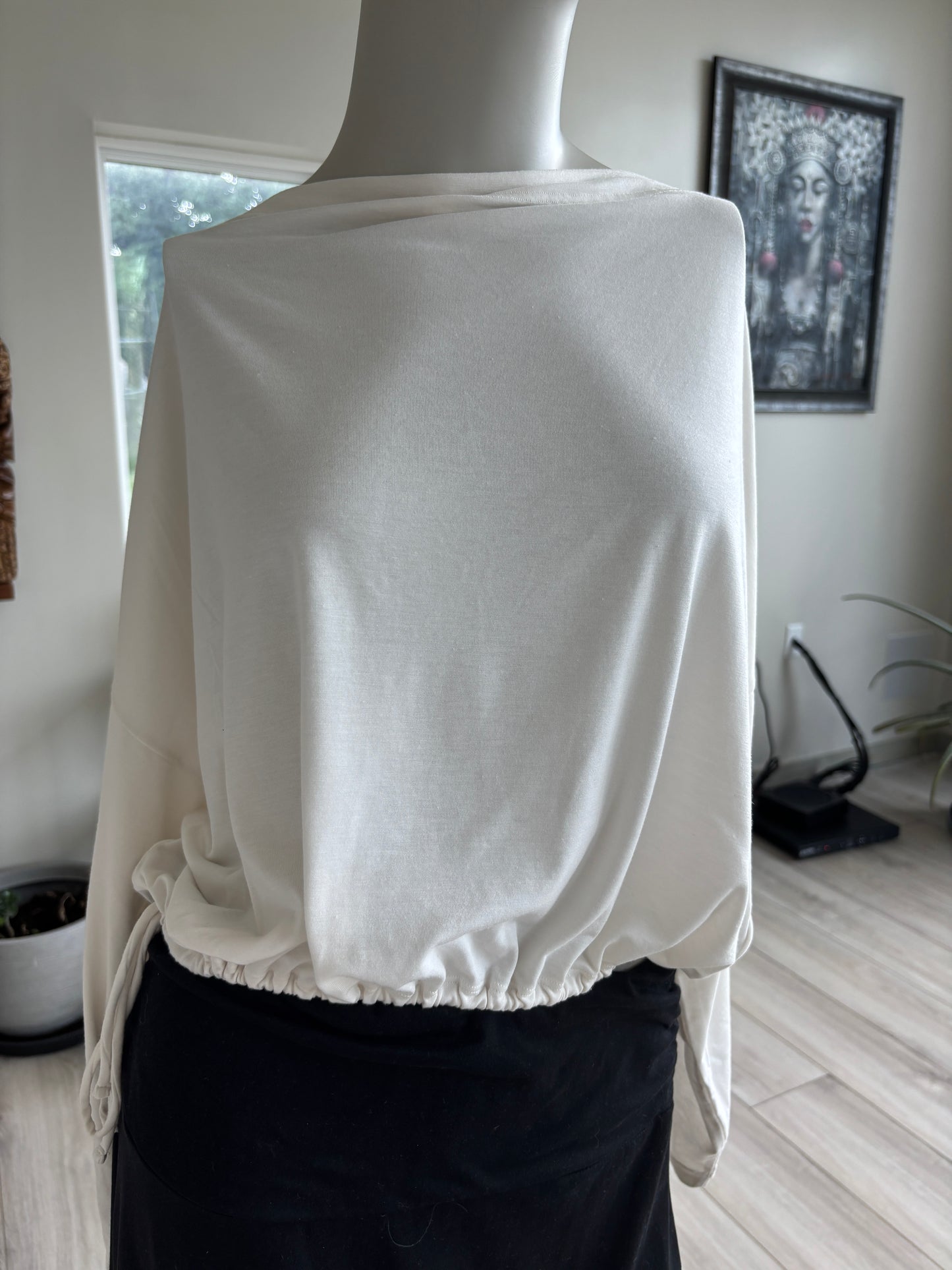 Athleta warm ivory yoga top with a draped boat neckline, long tapered sleeves, and adjustable cinch hem.