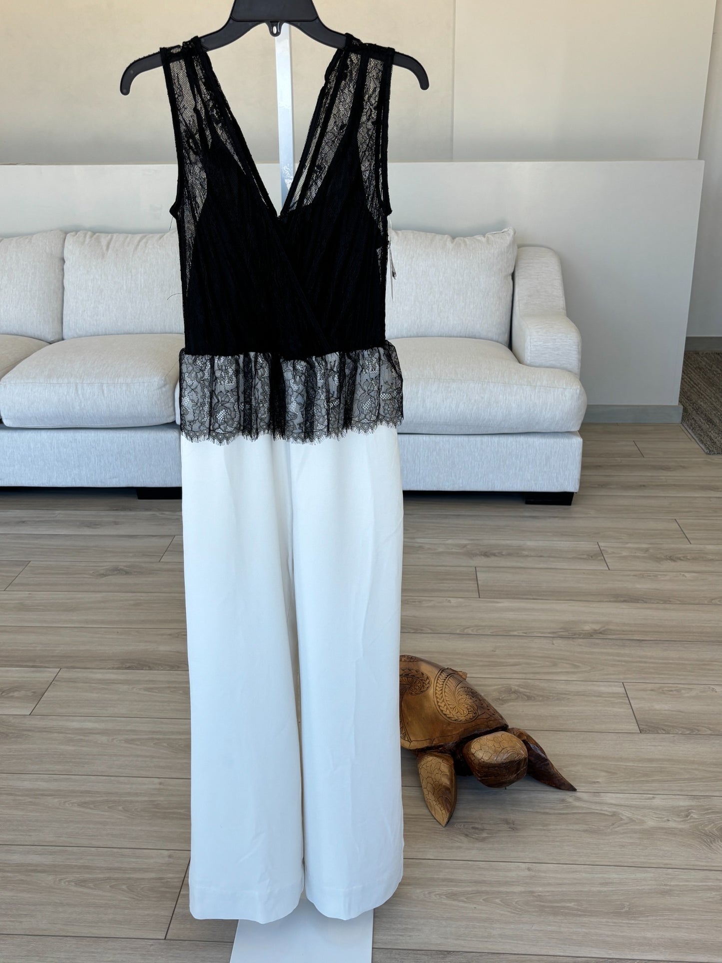 Black lace overlay jumpsuit with striking ivory wide leg pants and elegant contrast