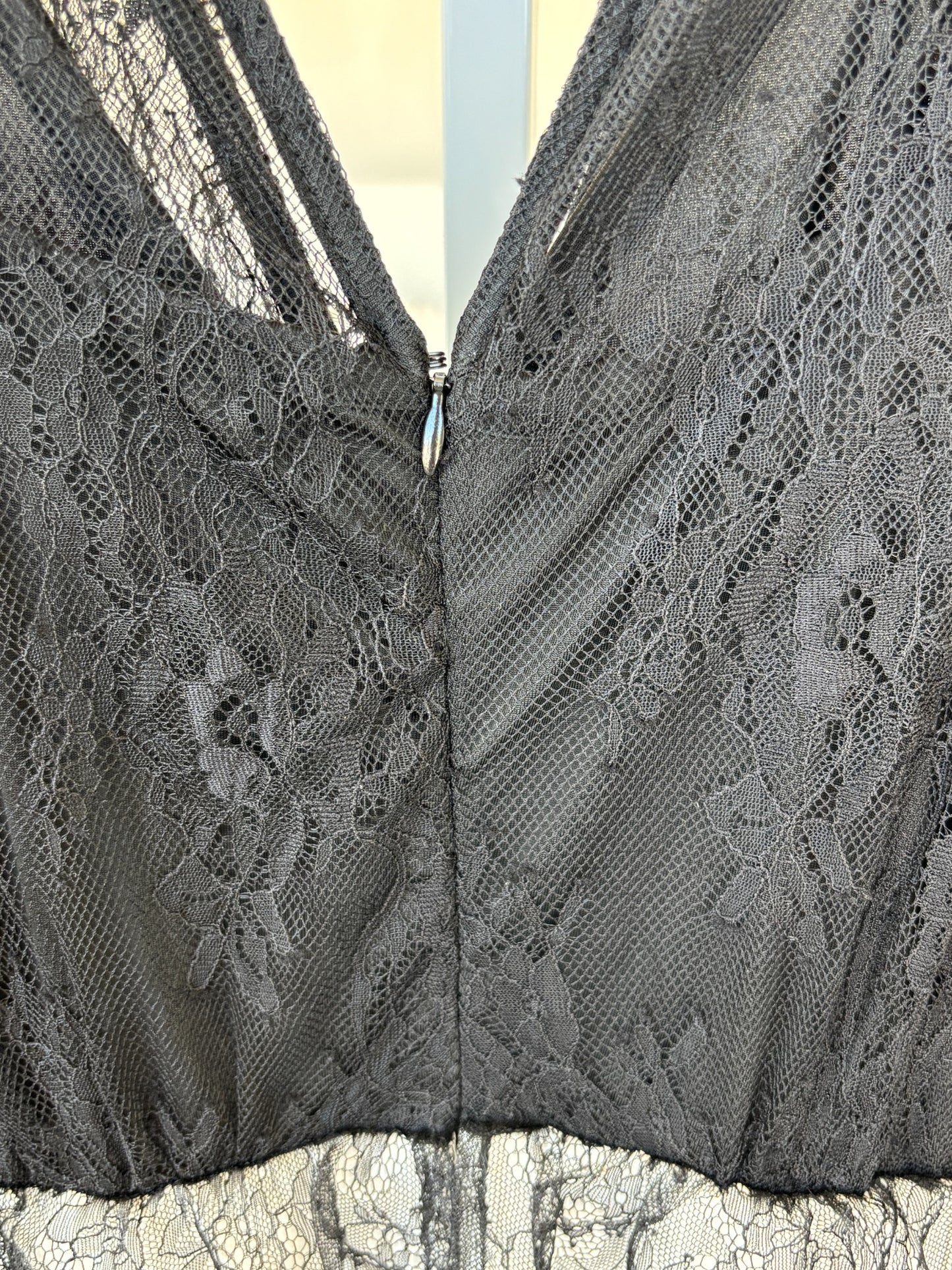 Elegant wide leg jumpsuit with black lace bodice and polished ivory pants