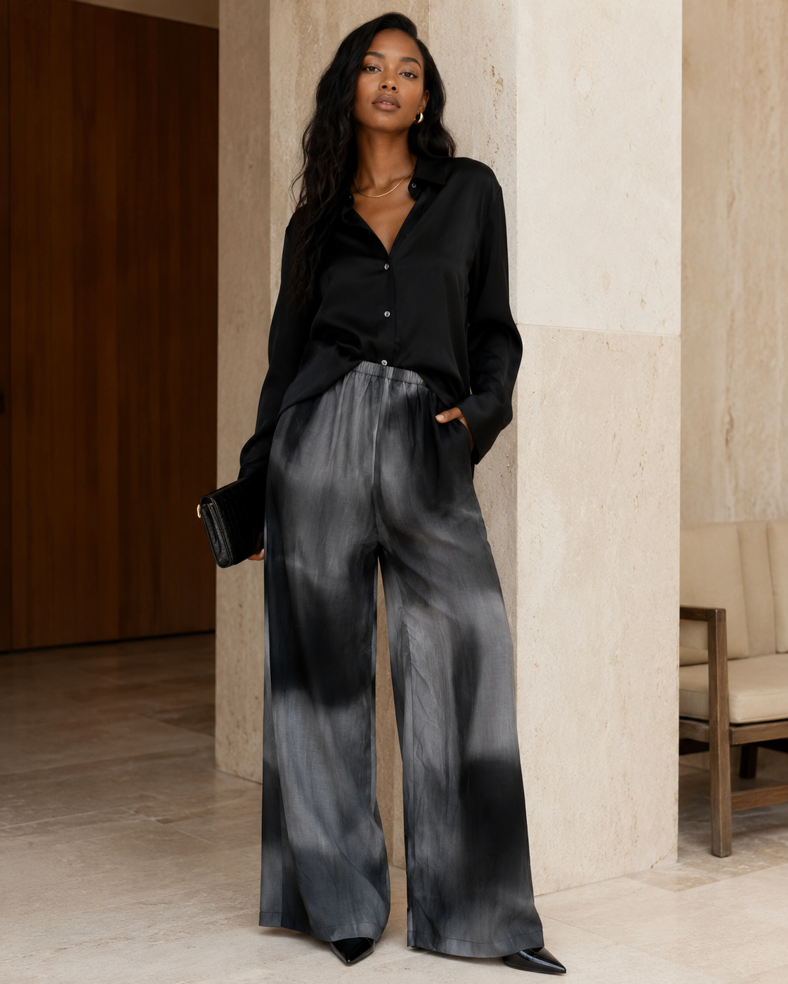 styling DISSH gray and black silk-cotton wide-leg pants with a black satin blouse and pointed-toe shoes.