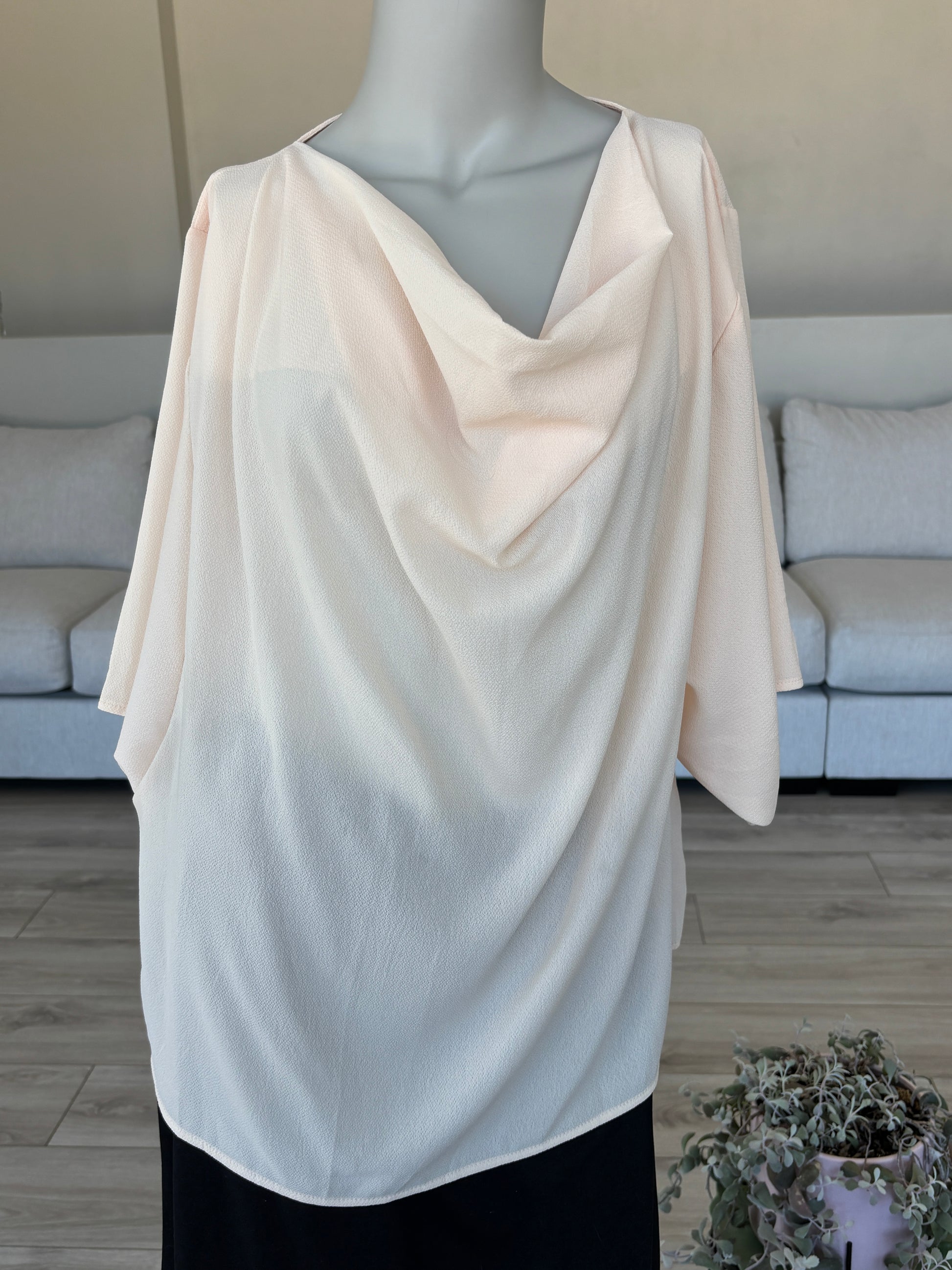 Peach blouse styled on a model showing flowy elbow length sleeves and soft drape