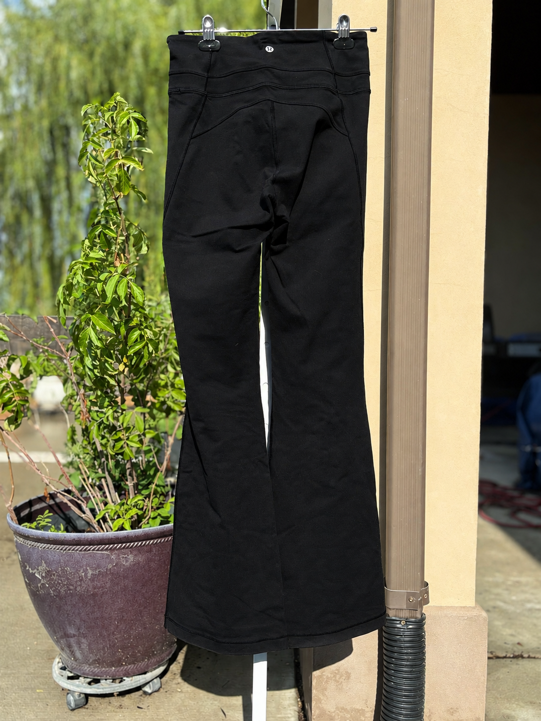 Lululemon black bootcut yoga pants with a fitted hip, gently flared hem, and comfortable supportive waistband.