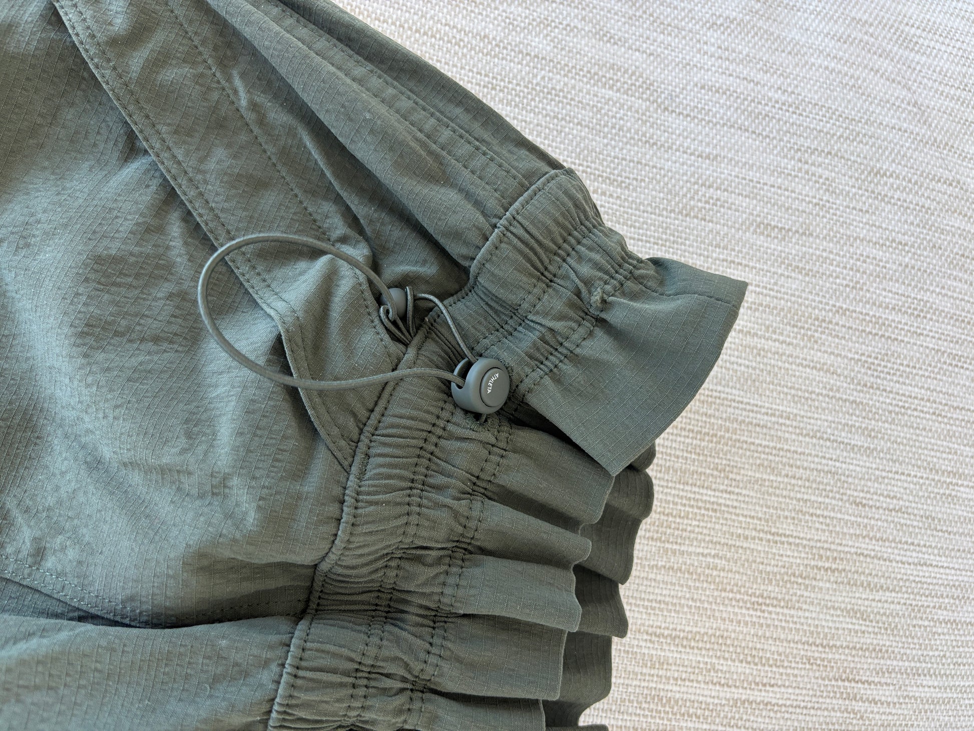 Athleta dark olive nylon spandex pants size 6 styled with sneakers for a polished sporty look from Adored Again boutique
