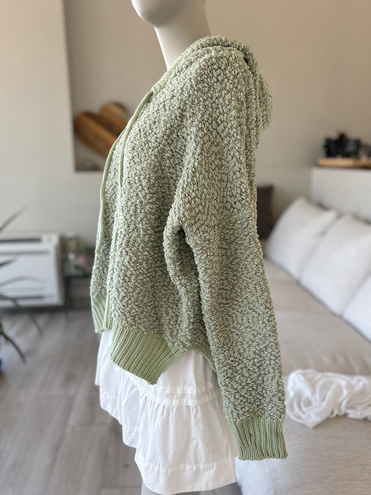 POL sage-green hooded sweater with a broad ribbed high-low hem and deep side vents