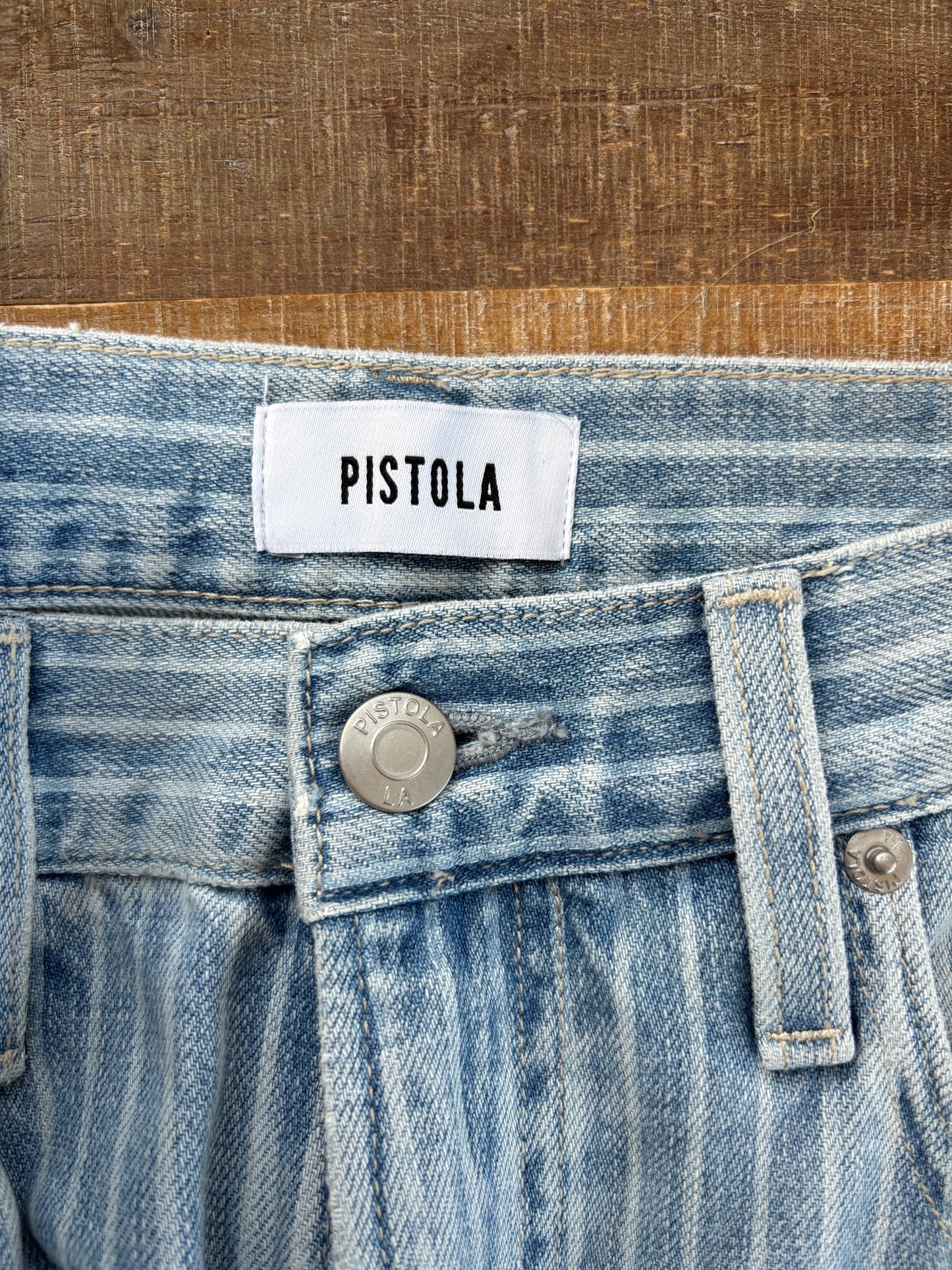 Flat lay of Pistola striped cropped jeans with white sneakers, keys, sunglasses, and errands-day accessories.