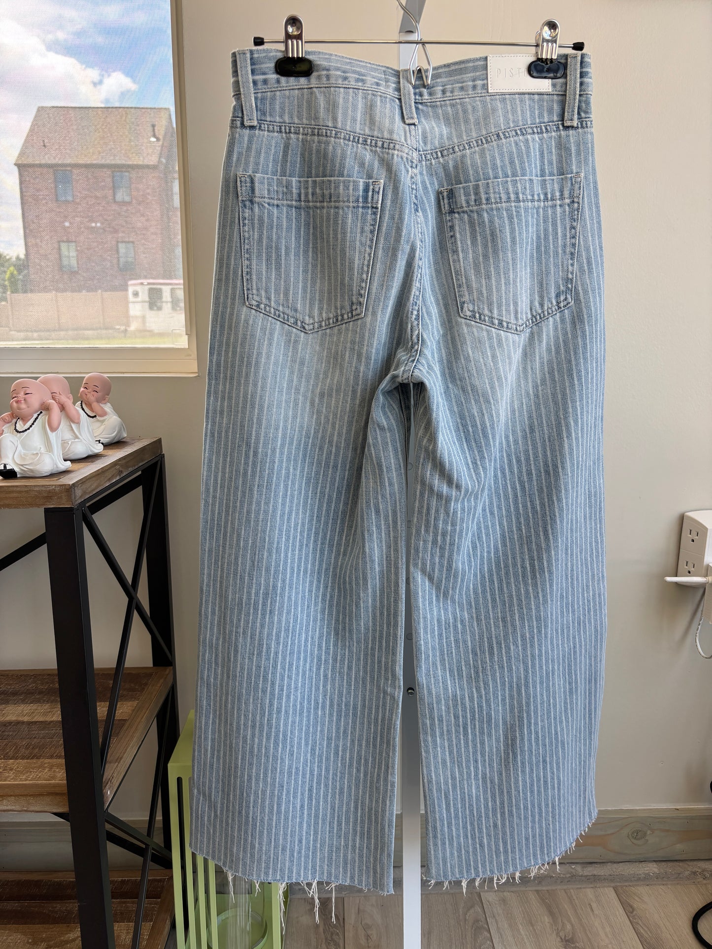 Woman shopping in a convenience store wearing Pistola striped wide leg cropped jeans and white sneakers.