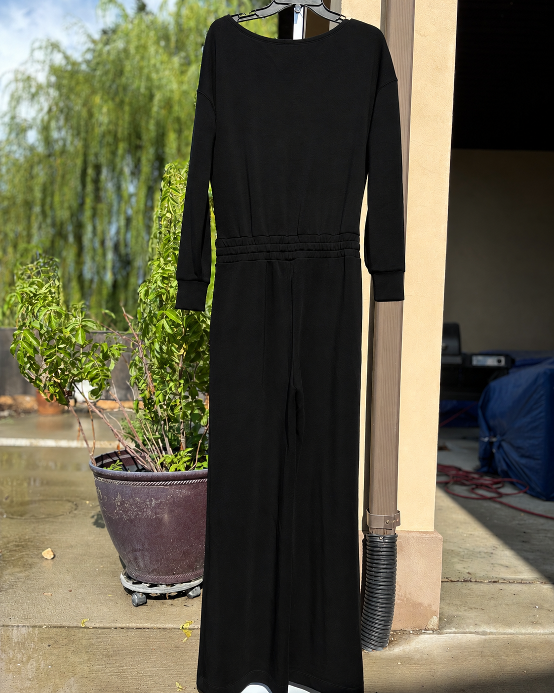 SPANX AirEssentials Very Black wide-leg jumpsuit with silky-soft spacer fabric, long sleeves, side pockets, and an adjustable waist.