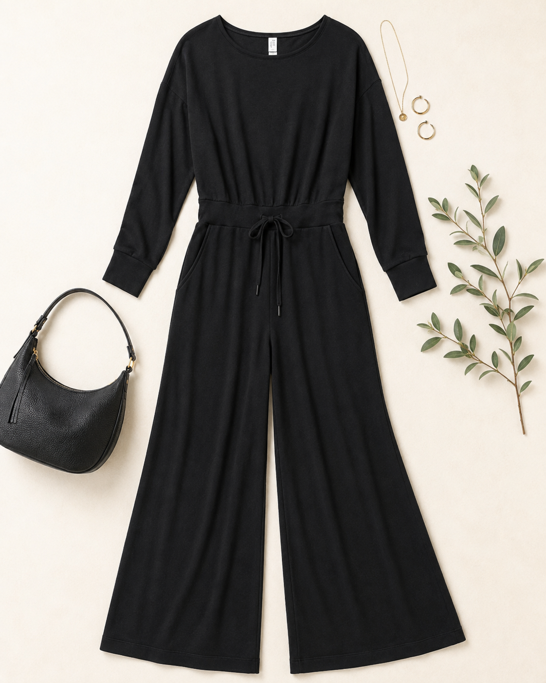 Black SPANX modal-blend jumpsuit featuring long sleeves, a fluid wide-leg silhouette, tie waist, and soft draped fabric.