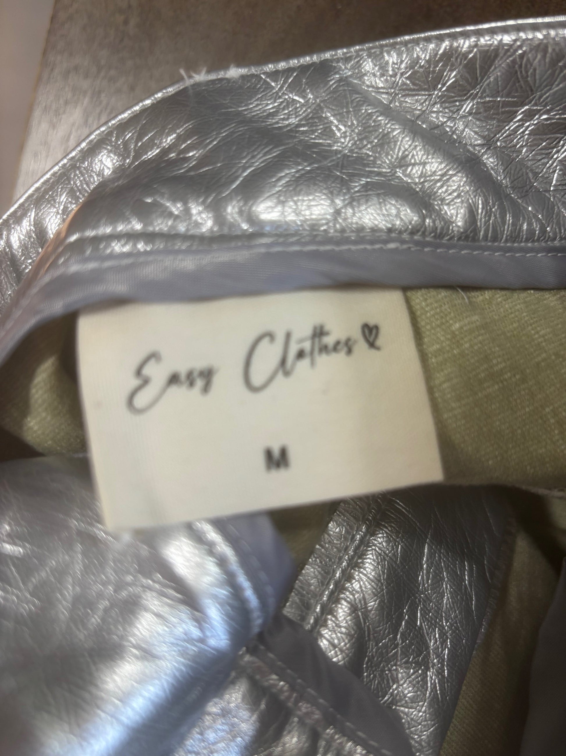 Additional detail shot of silver solstice trousers Size M-showing condition and styling details. Tag showing brand and size. New