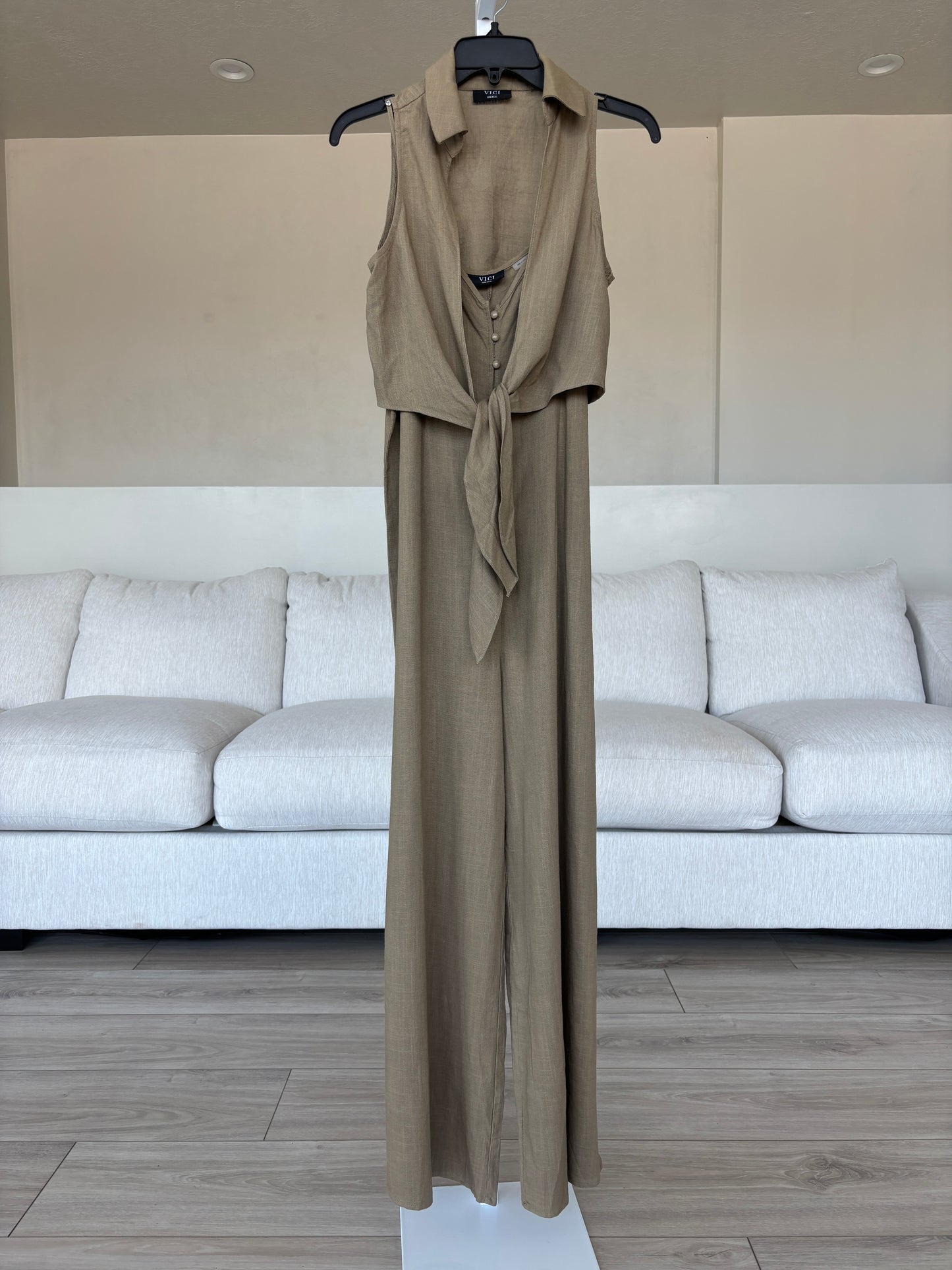 Flat lay of VICI linen blend jumpsuit and vest set with sun and moon inspired neutral accessories.
