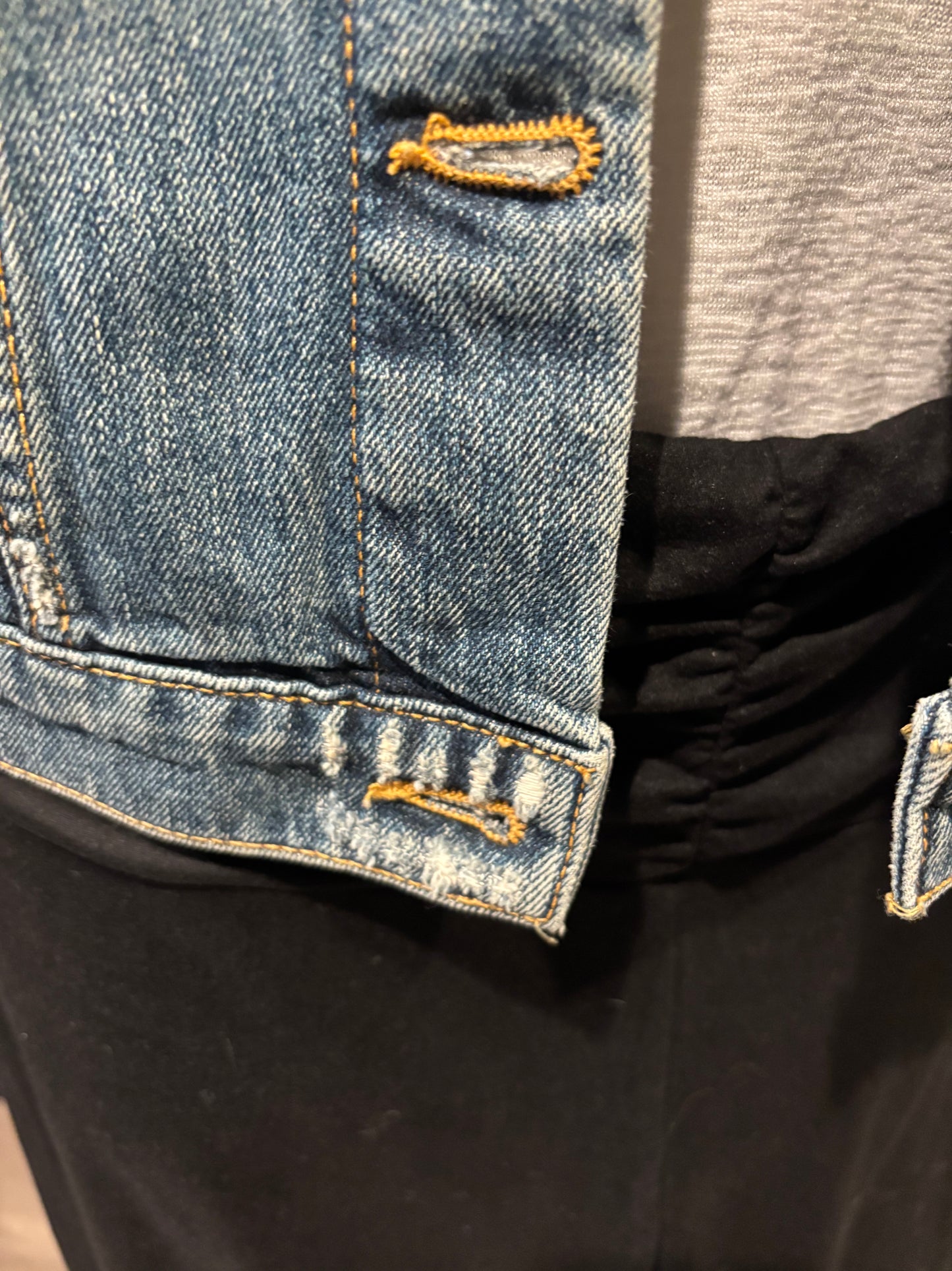 Close-up of blue denim jeans with decorative stitching intensional distressing shown